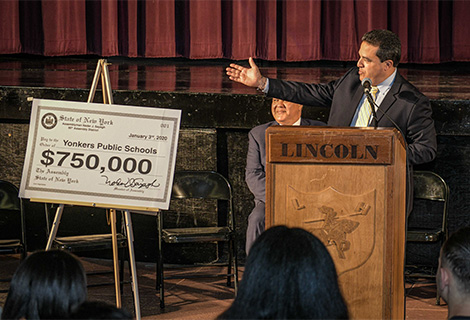  Superintendent of Schools stands with ceremonial check