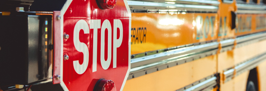 Image of a yellow school bus with a prominent red stop sign 