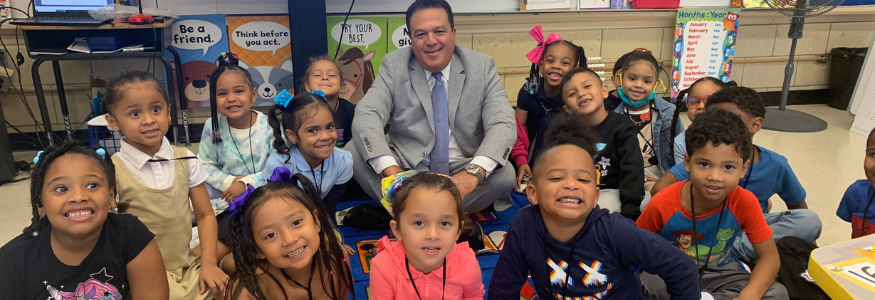 A group of young students with Superintendent Quezada